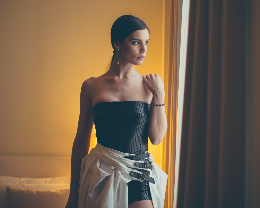 Woman in sleeveless black top and black skirt 